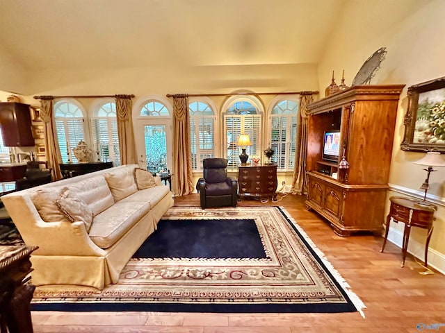 living room featuring light wood-type flooring and vaulted ceiling