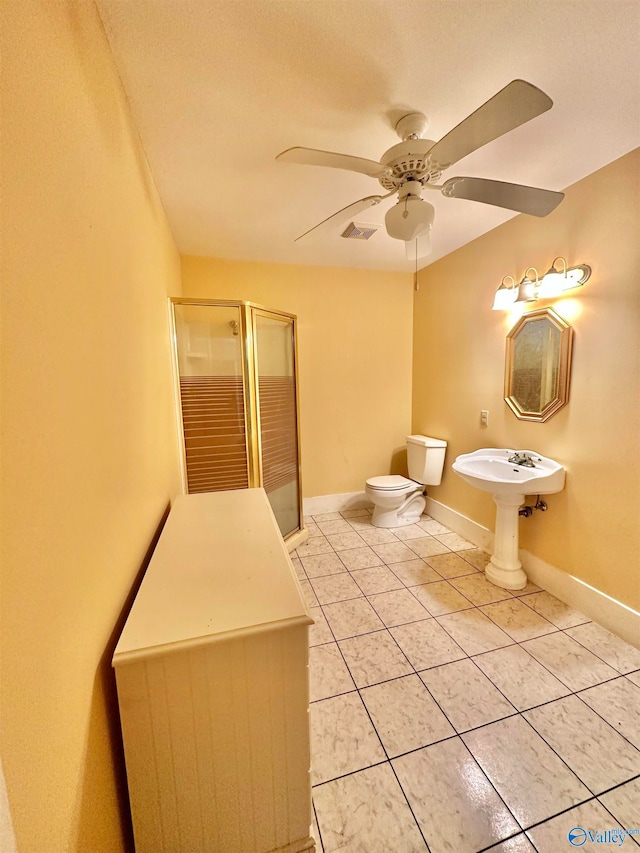 bathroom featuring tile patterned flooring, a textured ceiling, a shower with shower door, ceiling fan, and toilet