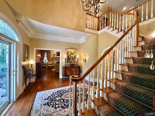 foyer entrance with dark hardwood / wood-style floors, a high ceiling, and crown molding