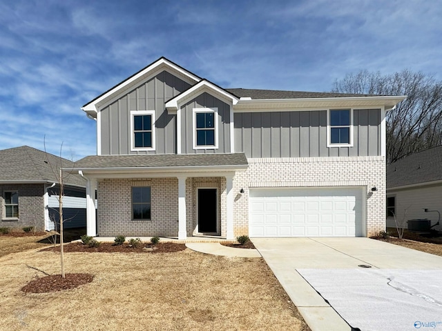 traditional-style house with a garage, brick siding, board and batten siding, and driveway