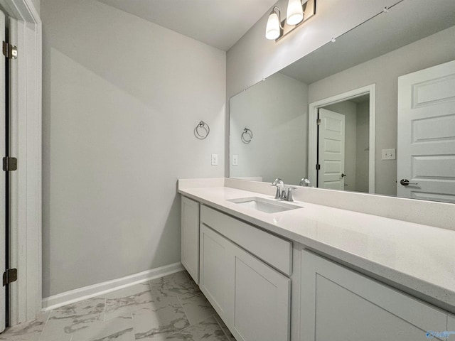 bathroom featuring marble finish floor, vanity, and baseboards