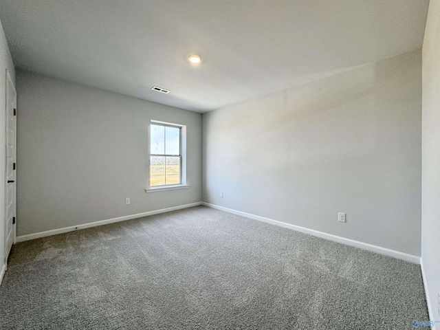 carpeted empty room with visible vents and baseboards