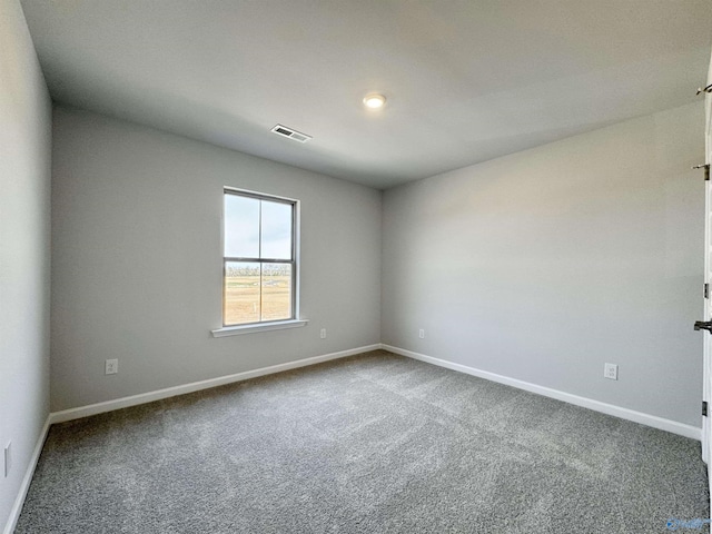 carpeted spare room with baseboards and visible vents