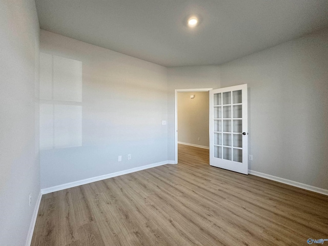 spare room with wood finished floors and baseboards