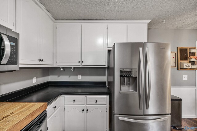 982 Bell Factory Rd, Huntsville, AL 35811 - kitchen featuring a textured ceiling, white cabinets, and appliances with stainless steel finishes
