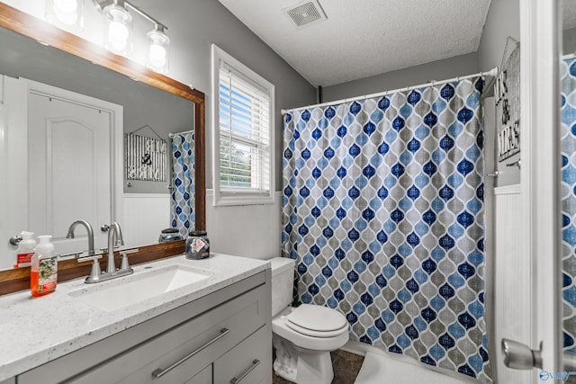 982 Bell Factory Rd, Huntsville, AL 35811 - bathroom featuring a wainscoted wall, toilet, vanity, visible vents, and a textured ceiling