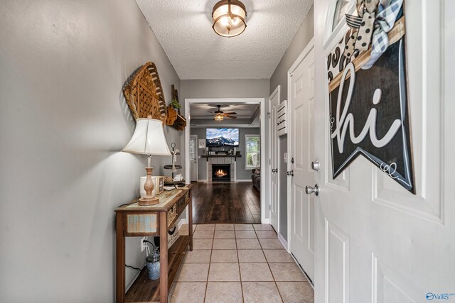 982 Bell Factory Rd, Huntsville, AL 35811 - foyer with ceiling fan, a fireplace, baseboards, a textured ceiling, and light tile patterned flooring