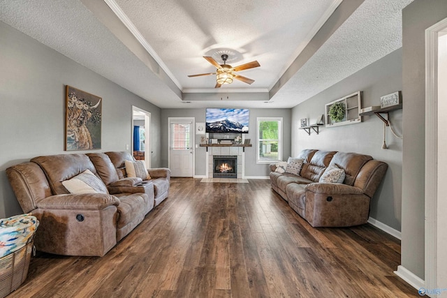 982 Bell Factory Rd, Huntsville, AL 35811 - living area with a textured ceiling, hardwood / wood-style flooring, a raised ceiling, a tile fireplace, and a ceiling fan