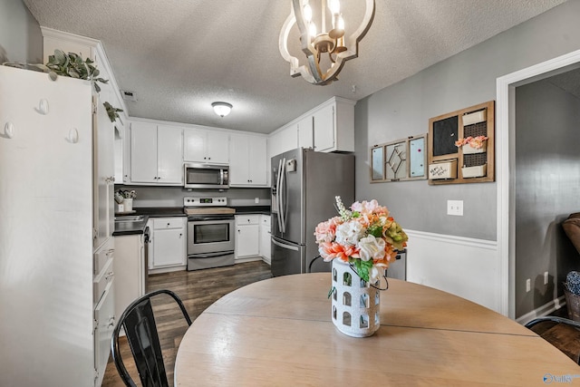 982 Bell Factory Rd, Huntsville, AL 35811 - dining space featuring dark wood finished floors, a chandelier, and a textured ceiling
