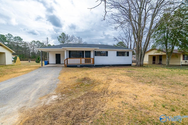 ranch-style home with a carport, a front yard, and covered porch