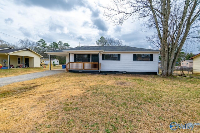 ranch-style home featuring a front yard, a carport, and covered porch