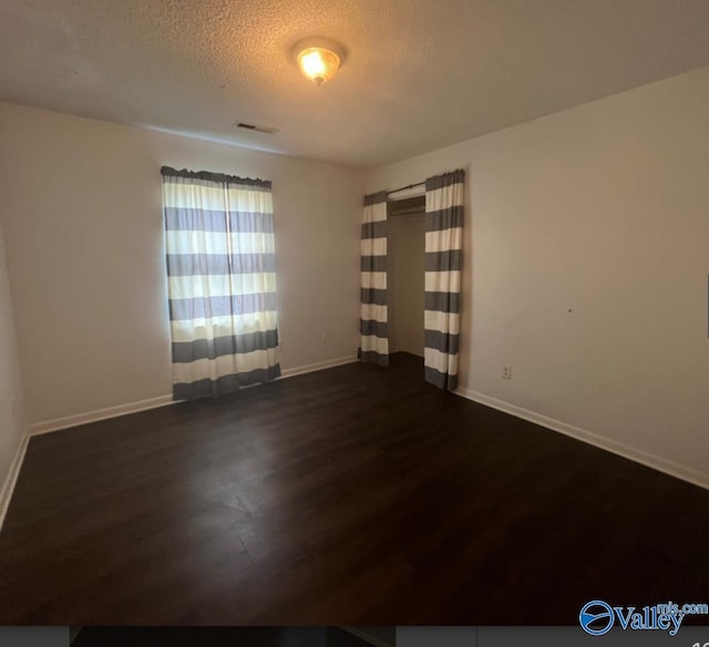 1008 Brighton Cir, Huntsville, AL 35803 - empty room featuring dark wood-style flooring, baseboards, and a textured ceiling