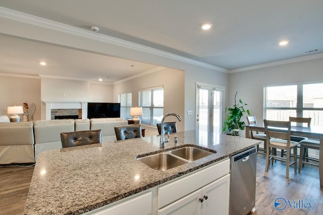 kitchen featuring dishwasher, a kitchen island with sink, stone counters, sink, and white cabinetry