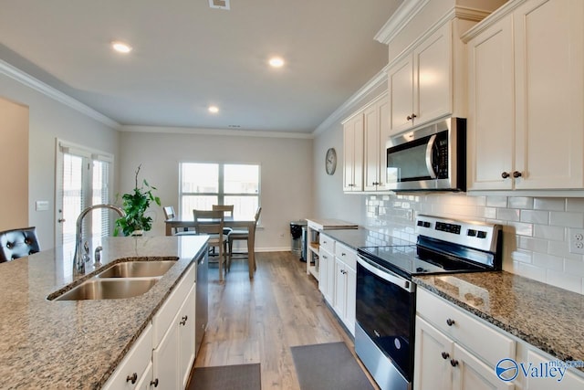 kitchen featuring white cabinets, light stone counters, sink, and stainless steel appliances