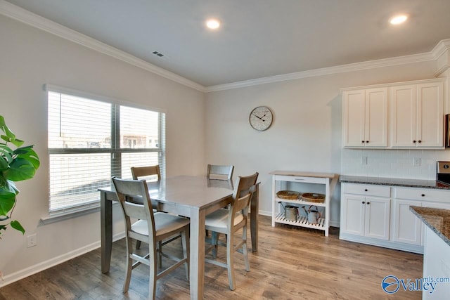 dining room featuring hardwood / wood-style floors and crown molding