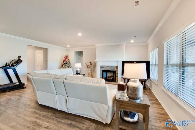 living room featuring hardwood / wood-style flooring, crown molding, and a fireplace