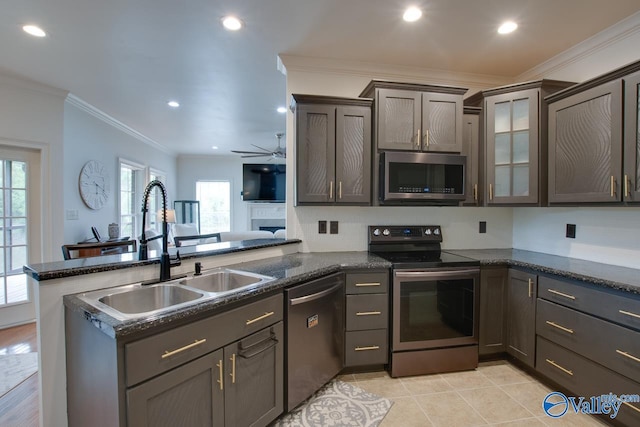 kitchen featuring appliances with stainless steel finishes, a peninsula, recessed lighting, and a sink