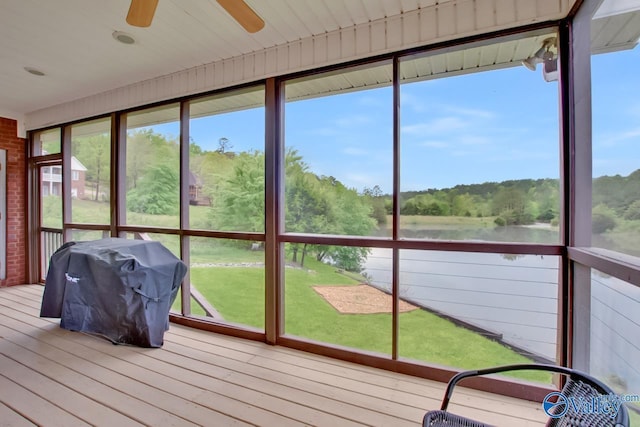 unfurnished sunroom with ceiling fan