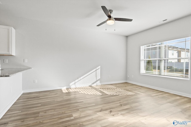 unfurnished living room featuring ceiling fan and light hardwood / wood-style flooring