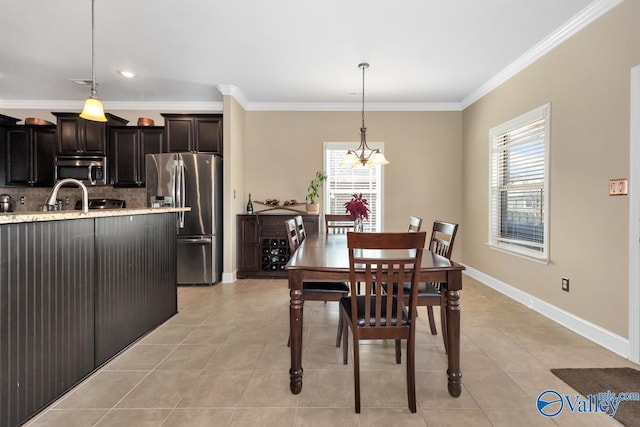 dining area featuring light tile patterned floors, baseboards, and ornamental molding