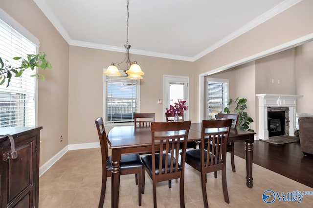 dining area with plenty of natural light, baseboards, crown molding, and a stone fireplace