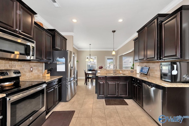 kitchen with light tile patterned floors, stainless steel appliances, a peninsula, a sink, and ornamental molding