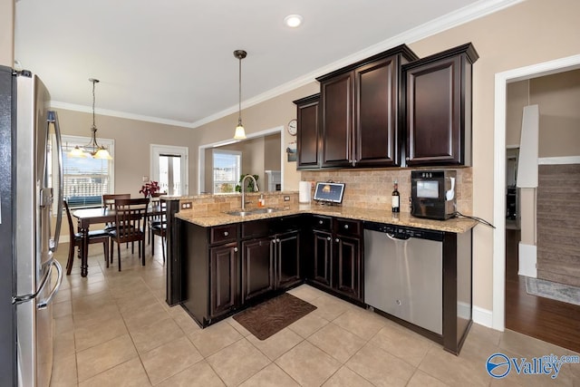 kitchen featuring appliances with stainless steel finishes, backsplash, a sink, and crown molding