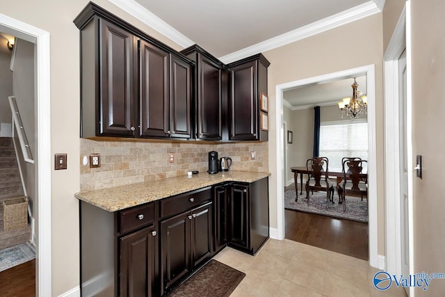 kitchen with dark brown cabinets, backsplash, crown molding, and light tile patterned flooring