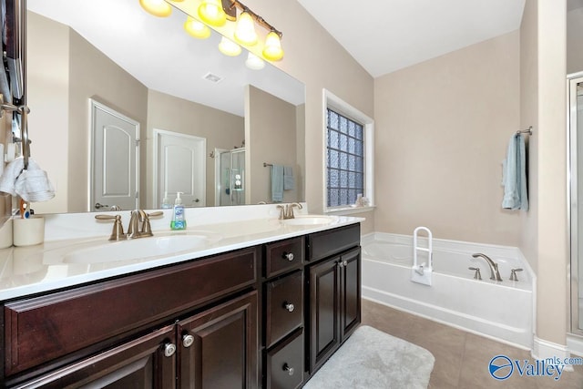 full bathroom featuring a garden tub, a stall shower, tile patterned flooring, and a sink