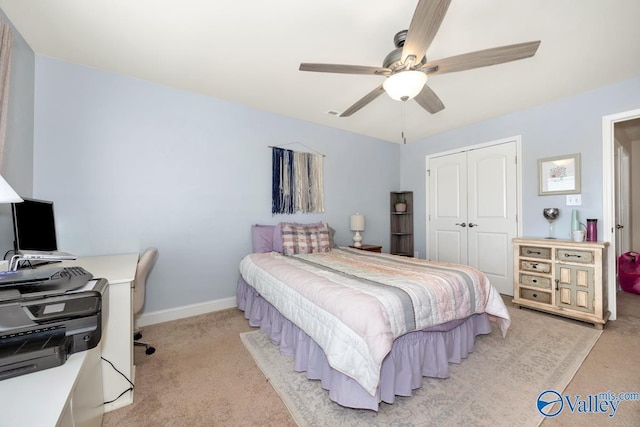 bedroom featuring baseboards, a closet, a ceiling fan, and light colored carpet