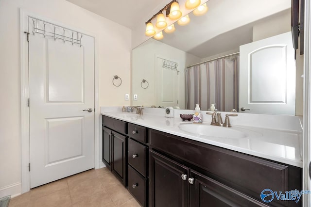 bathroom with tile patterned flooring, a sink, and double vanity