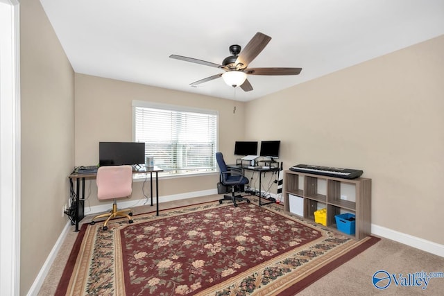 carpeted office with ceiling fan and baseboards