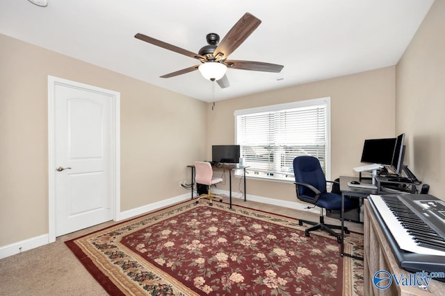 office area with carpet flooring, a ceiling fan, and baseboards