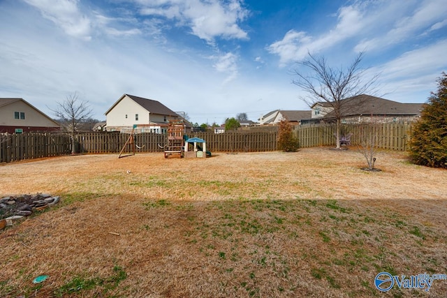 view of yard with a playground and a fenced backyard