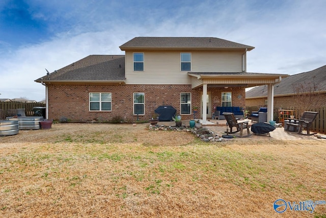 rear view of house featuring a yard, brick siding, a patio area, and fence