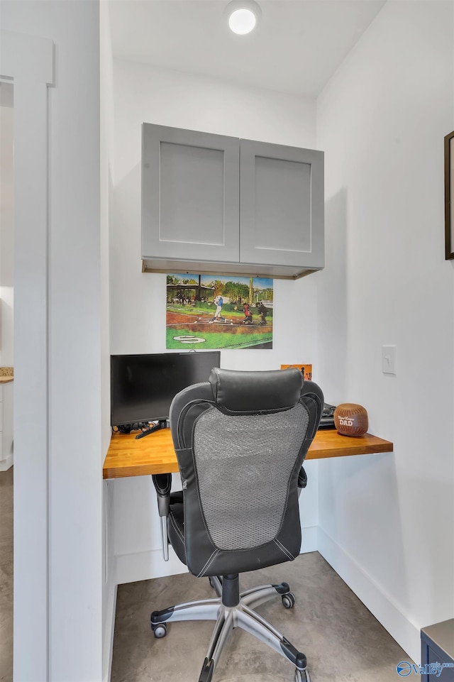 home office featuring concrete flooring