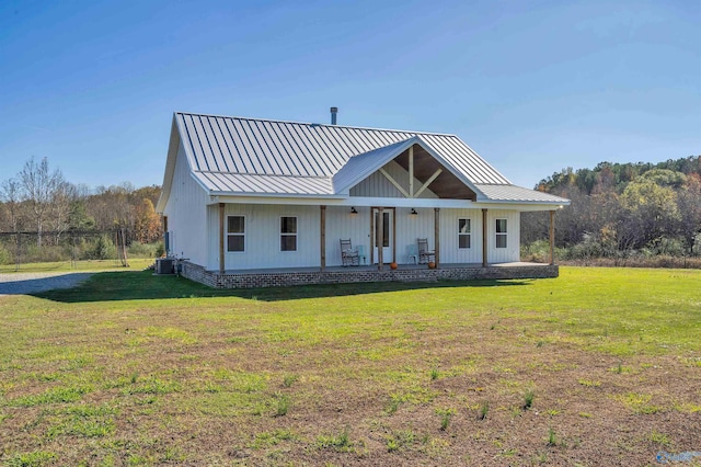 modern inspired farmhouse with a front yard, central AC unit, and covered porch