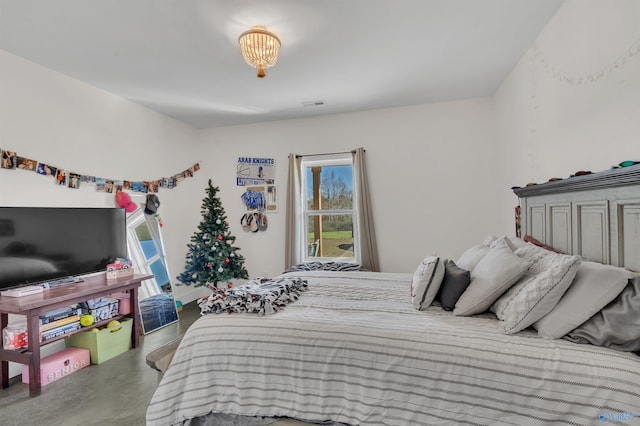 bedroom with a chandelier and concrete flooring