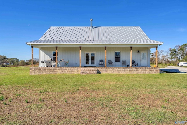 back of property featuring a lawn and french doors