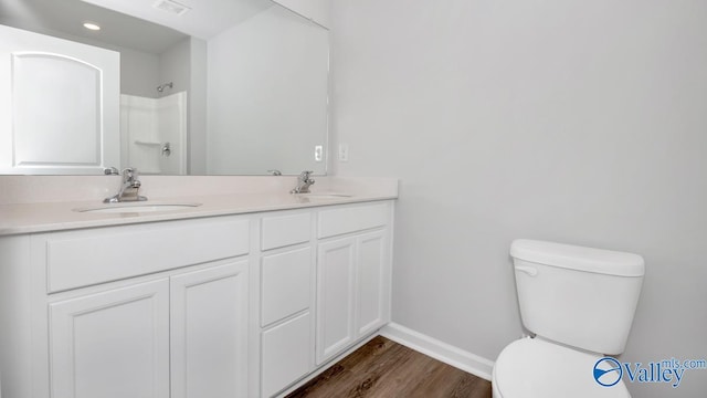 bathroom with vanity, hardwood / wood-style flooring, a shower, and toilet