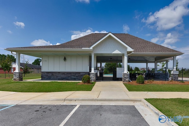 view of front facade with ceiling fan and a front yard