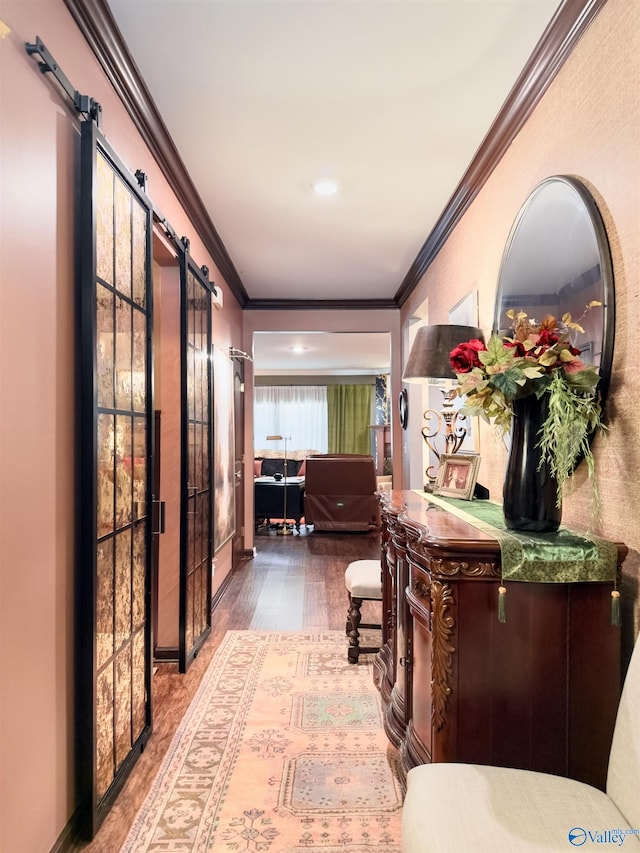 corridor featuring crown molding, a barn door, and hardwood / wood-style floors