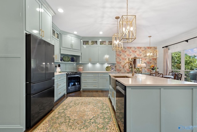 1176 N Lake Forest Dr, Southside, AL 35907 - kitchen with a sink, dark wood-style flooring, stainless steel range with electric cooktop, freestanding refrigerator, and an inviting chandelier