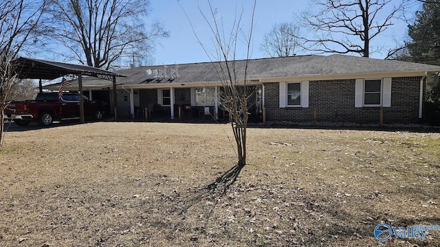 ranch-style house featuring a detached carport, brick siding, and driveway