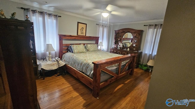 bedroom with ceiling fan, ornamental molding, and wood finished floors