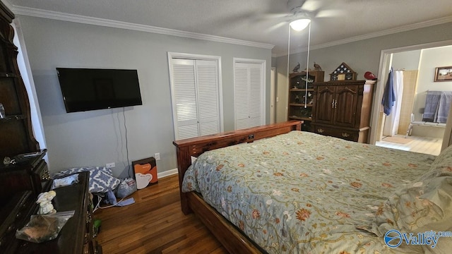 bedroom with crown molding, multiple closets, a ceiling fan, wood finished floors, and baseboards