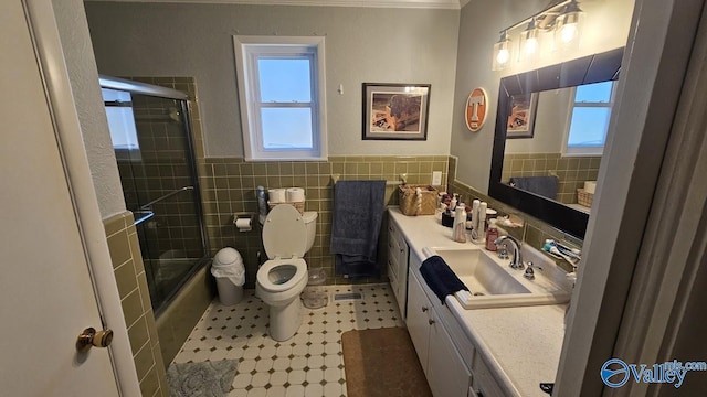 bathroom with toilet, a wealth of natural light, vanity, and tile walls