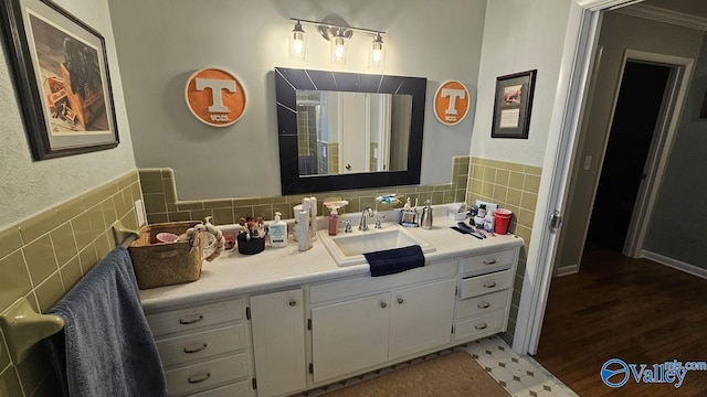 bathroom featuring wainscoting, vanity, and tile walls