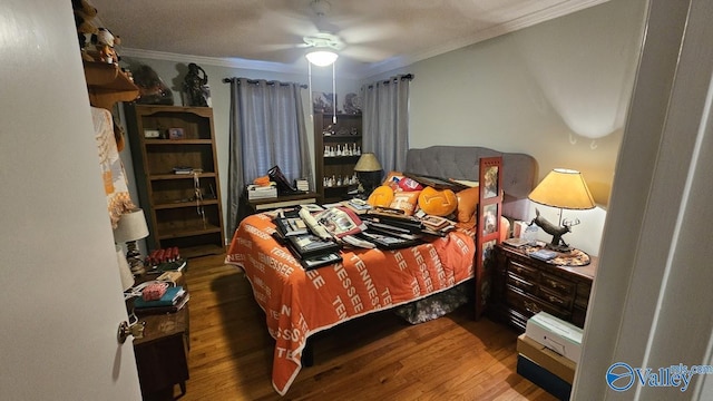 bedroom with wood finished floors, a ceiling fan, and crown molding