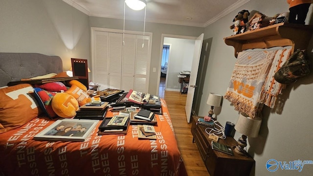 bedroom featuring a closet, crown molding, and wood finished floors